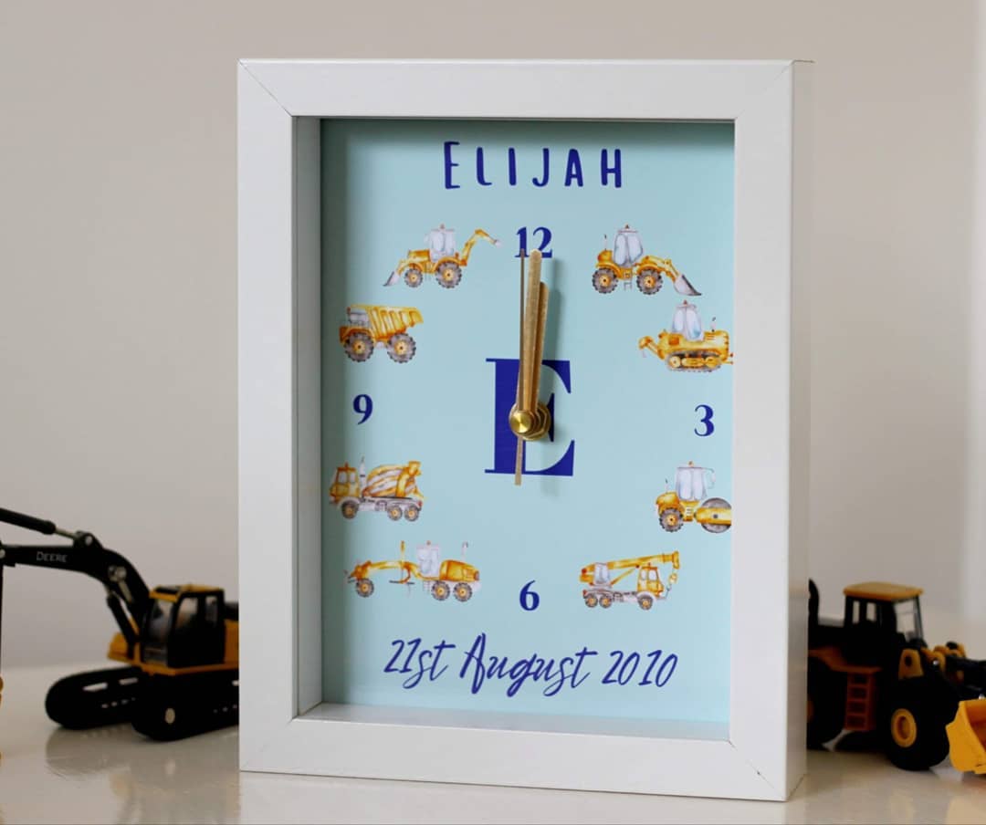 Personalised picture clock with diggers and construction vehicles sitting on table