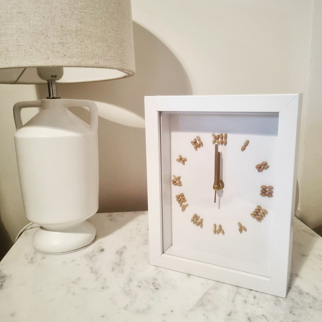 Clock with wheat grains in place of numbers sitting on table
