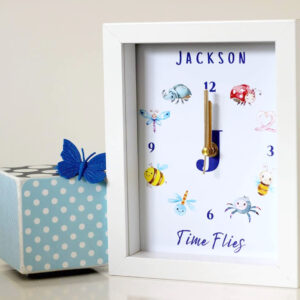 Image of personalised childrens clock with insects and bugs on it sitting on table