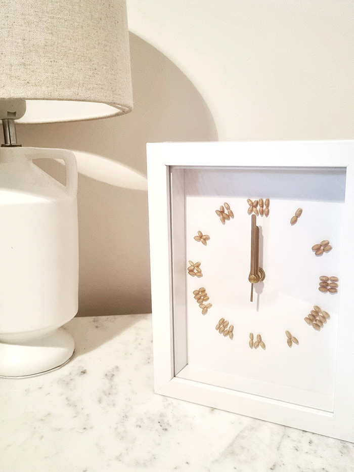 Clock with wheat grains used to symbolise numbers sitting on a table