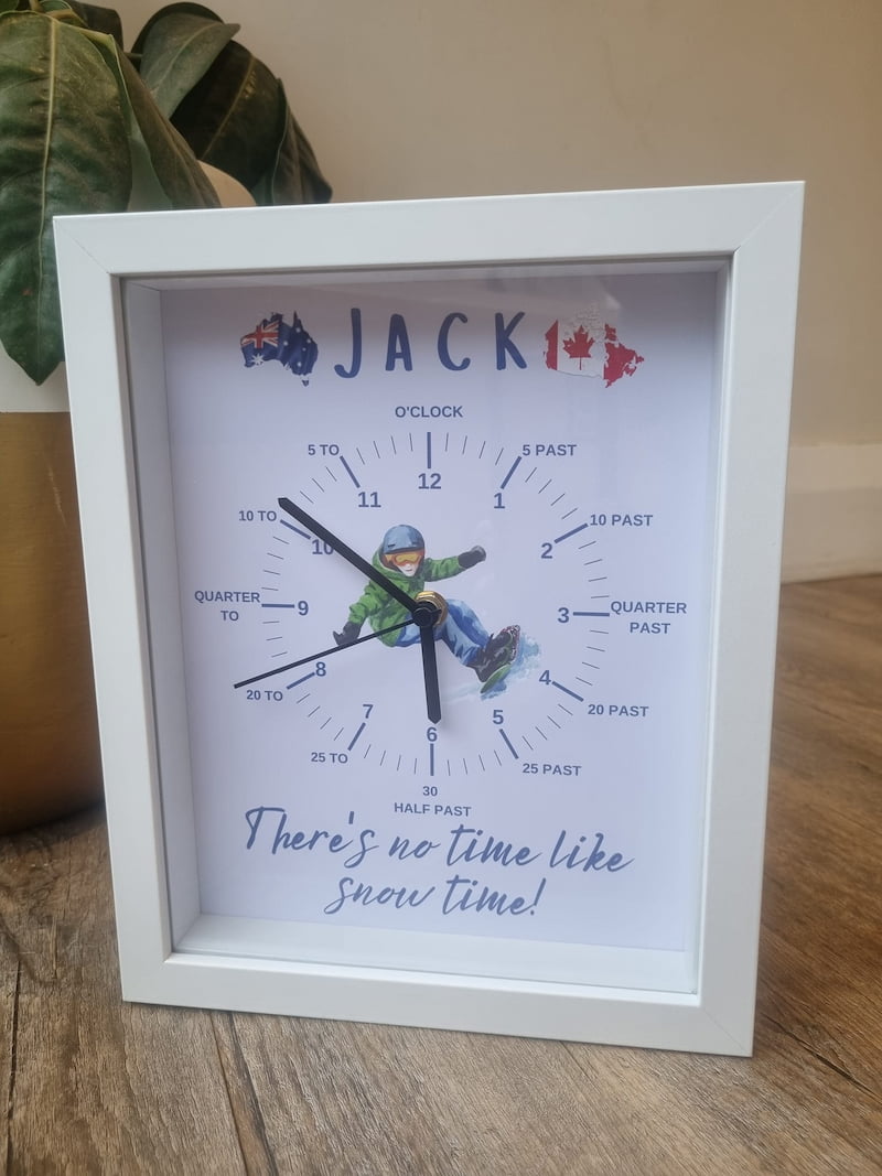 Custommade learning clock with snowboarding character in the middle sitting on a table