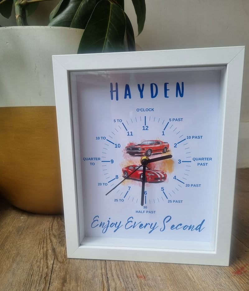 Personalised learning clock with vintage cars in the middle sitting on a side table